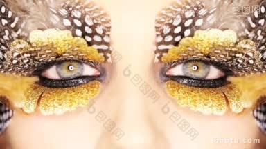 特写的一个女人的眼睛与<strong>醒目</strong>的创意化妆金色和斑点羽毛在一个美丽和时尚的概念